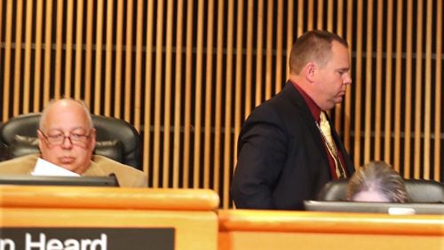 Tommy Hunter (right), the District 3 leader that recently called U.S. Rep. John Lewis a “racist pig” on Facebook, walks out just before public comments as more protesters demand his resignation during the Gwinnett County Board of Commissioners public hearing session on Tuesday Feb. 28, 2017, in Lawrenceville. Curtis compton/ccompton@ajc.com