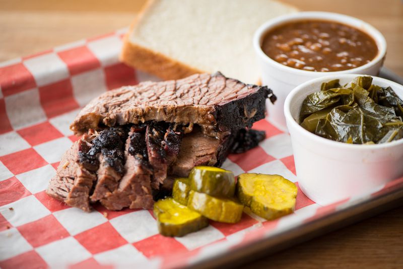 King Barbecue’s sliced brisket plate, served with collard greens, beans and pickles. CONTRIBUTED BY MIA YAKEL