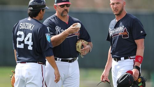 Sal Fasano works with veteran Braves catchers Kurt Suzuki and Tyler Flowers during a spring-training workout.