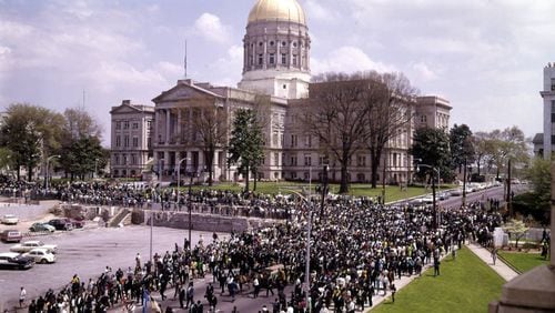 The funeral procession for Martin Luther King Jr. passes in front of Atlanta City Hall (out of frame) near the Georgia Capitol building. The flag in front of the Capitol building is flying at half-staff over the objection of Gov. Lester Maddox. (J. C. Lee / AJC Collection at GSU Library AJCNS1968-04-09c)