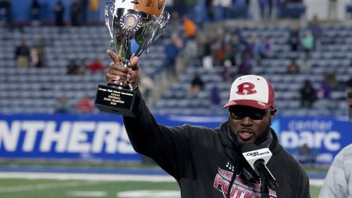 Warner Robins coach Marquis Westbrook celebrates with the trophy after their 62-28 win against against Cartersville in the Class 5A state high school football final Dec. 30, 2020, at Center Parc Stadium in Atlanta. (Jason Getz/For the AJC)