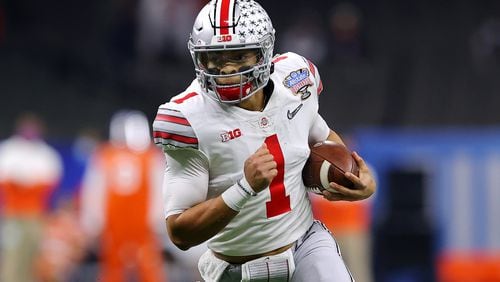 Showing off his other dimension, Ohio State quarterback Justin Fields runs the ball against Clemson during the College Football Playoff semifinal game in January. (Kevin C. Cox/Getty Images/TNS)