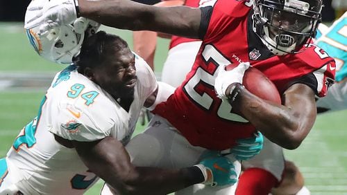 Falcons running back Tevin Coleman separates Miami linebacker Lawrence Timmons from his helmet on the way to a touchdown. (Curtis Compton/ccompton@ajc.com)
