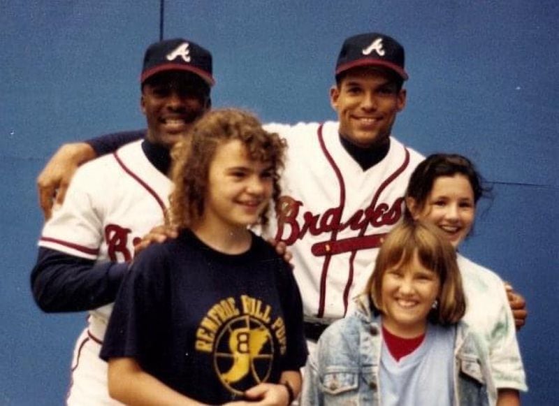 Gretchen Kaney (left), then in middle school, and two friends pose for a photo with Braves stars Ron Gant and David Justice in 1991.