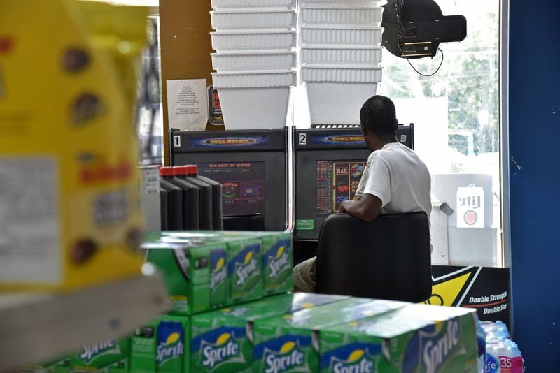 A customer plays a coin-operated “amusement” machine inside a convenience store in Pittsburgh neighborhood in 2017. Assets seized from investigations conducted by the state revenue department were used to purchase engraved firearms, pricey gym equipment and other questionable items, the AJC found. HYOSUB SHIN / HSHIN@AJC.COM