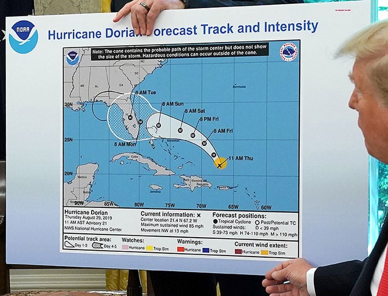 President Donald Trump references a map while talking to reporters about Hurricane Dorian in the Oval Office on Sept 4. The map proved controversial because it showed an early forecast track from Aug. 29 and appears to have been altered by a black marker to extend the hurricane's range to include Alabama.