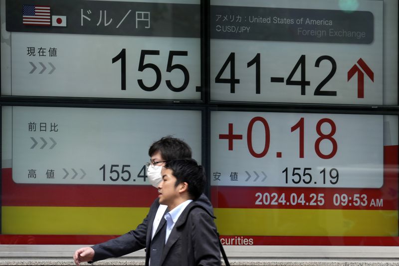 People walk in front of an electronic stock board showing U.S. Dollar/Japanese Yen exchange rate at a securities firm Thursday, April 25, 2024, in Tokyo. (AP Photo/Eugene Hoshiko)