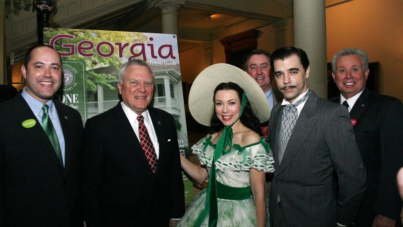 At about 9 a.m. on Tuesday, Gov. Nathan Deal attends a state Capitol ceremony to unveil Georgia’s new Gone With the Wind-themed tourism guide. Later he posed with actors portraying Scarlett O’Hara and Rhett Butler. From left to right: state Economic Development Commissioner Chris Carr, Gov. Nathan Deal. To the far right is state Rep. Ron Stephens, R-Savannah, head of the House Committee on Economic Development and Tourism. (The individual behind Scarlett O’Hara is unidentified).