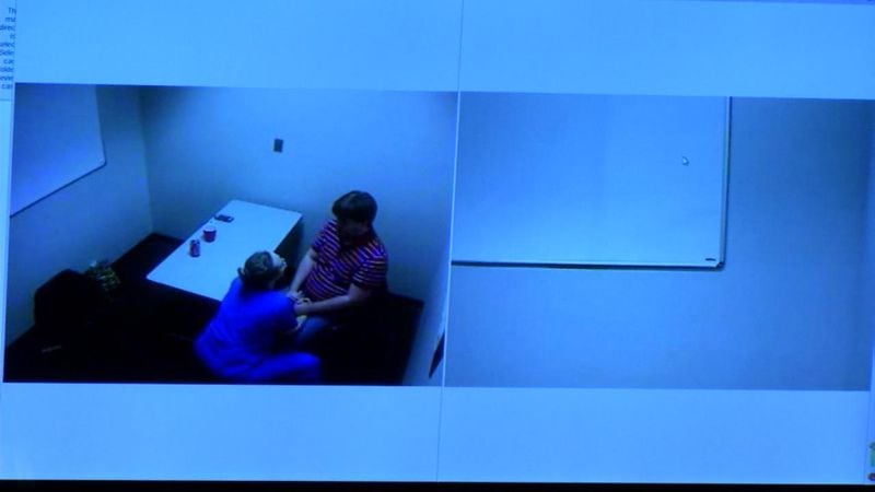 Leanna Harris comforts her husband Ross in an interrogation room, in this footage shown to jurors during Harris' murder trial at the Glynn County Courthouse in Brunswick, Ga., on Friday, Oct. 21, 2016. (screen capture via WSB-TV)