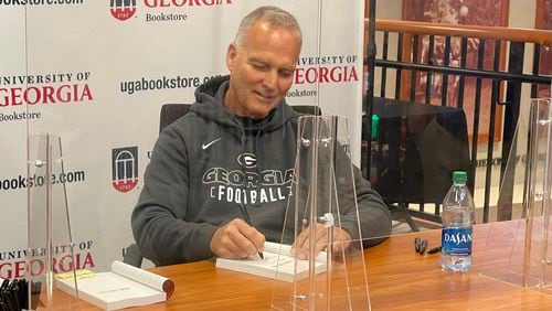 Former Georgia and Miami head football coach Mark Richt personalizes one of his books, Make The Call, during a signing at the UGA Bookstore in Athens, Ga., on Thursday, Sept. 16, 2021. (Photo by Chip Towers/ctowers@ajc.com)