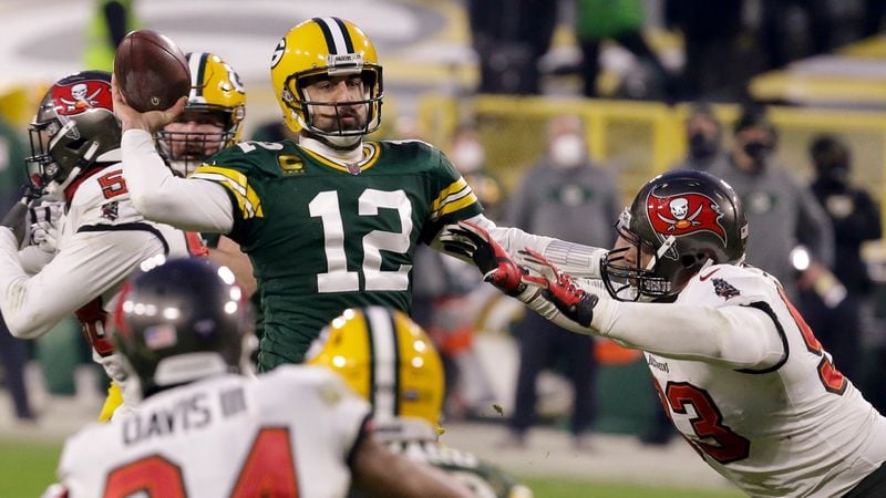 Green Bay Packers quarterback Aaron Rodgers (12) evades a tackle as he looks to pass against the Tampa Bay Buccaneers during the second half of the NFC championship game Sunday, Jan. 24, 2021, in Green Bay, Wis. (Mike Roemer/AP)