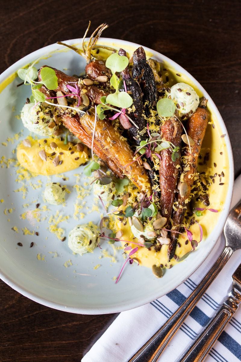 Roasted carrots at One Midtown Kitchen are pretty impressive, with acorn squash puree, dollops of goat cheese pesto, various toasted seeds, a cured egg yolk and wisps of micro greenery. CONTRIBUTED BY MIA YAKEL