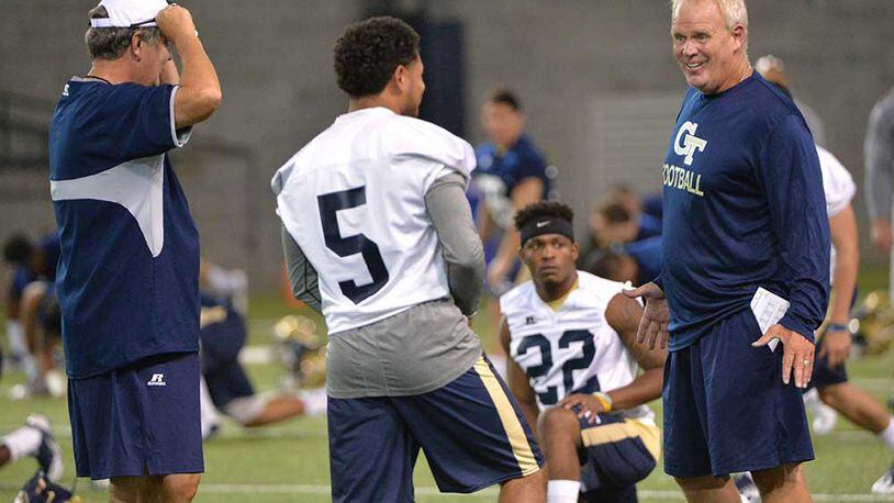 Assistant Andy McCollum talks with quarterback Justin Thomas as coach Paul Johnson looks on.