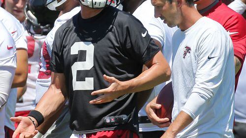 Matt Ryan and Falcons offensive coordinator Kyle Shanahan work out the details at camp. (Curtis Compton / ccompton@ajc.com)