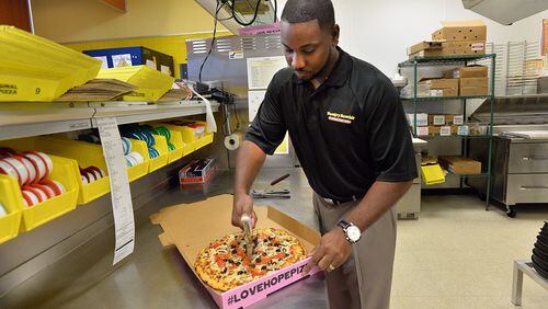 Preston Starr prepares a pizza for delivery at his Hungry Howie’s Pizza in Douglasville in this 2013 photo. He was seeking a loan backed by the Small Business Administration for a second restaurant in Smyrna, which he opened in 2014. This year, the SBA said it backed a record $1.4 billion in loans in Georgia. HYOSUB SHIN / HSHIN@AJC.COM