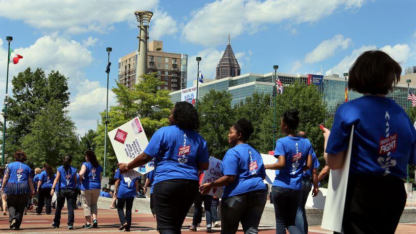 An estimated 450 American Cancer Society employees, volunteers and supporters march through Centennial Olympic Park in downtown Atlanta after a rally to celebrate the organization’s 100th birthday in 2013. The nonprofit announced layoffs June 10, 2020. File photo. (PHIL SKINNER/AJC)