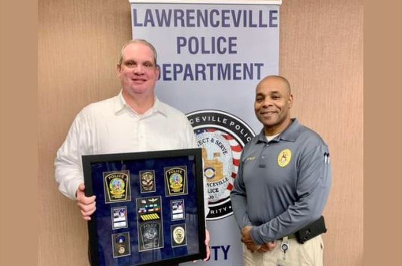 Lawrenceville Police Captain Ryan Morgan, left, celebrated his retirement in late December with the agency's assistant chief, Major Myron Walker, right. Morgan informed the city of his decision to retire the night before he was set to be interviewed by an independent investigator looking into sexual harassment within the agency.