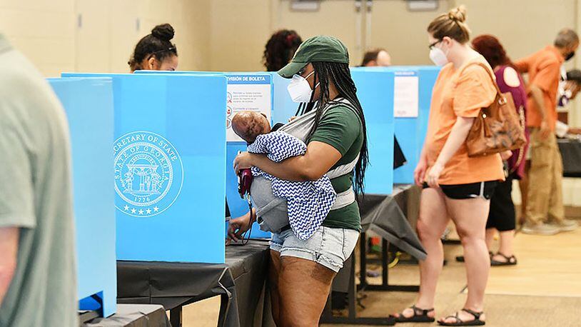 Caption: June 9, 2020 Norcross - Gwinnett County residents including Latanya Adams (center) with her 4-months old son Princeton cast their votes during the Georgia primary elections at Pinckneyville Community Center in Norcross on Tuesday, June 9, 2020. “I like new voting machine. It was easier to use.” Adams said.