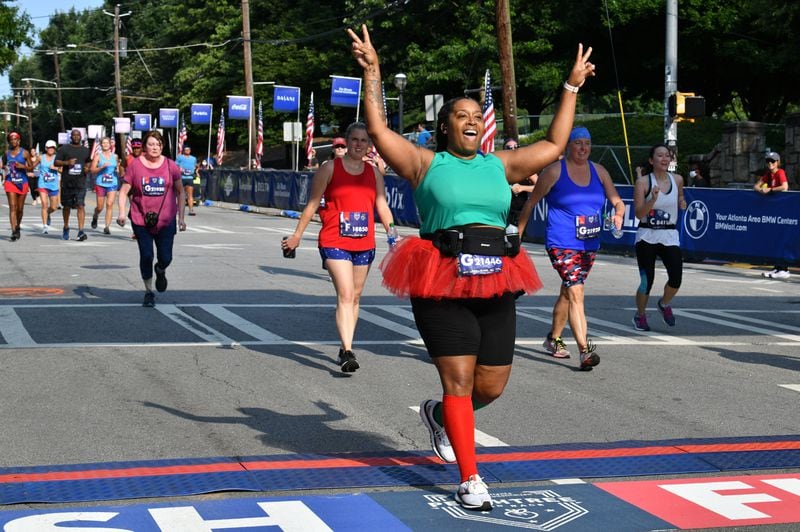 July 3, 2021 Atlanta - Jocelyn Wason celebrates as she crosses the finish line during the first day of 2021 Atlanta Journal-Constitution Peachtree Road Race on Saturday, July 3, 2021. (Hyosub Shin / Hyosub.Shin@ajc.com)