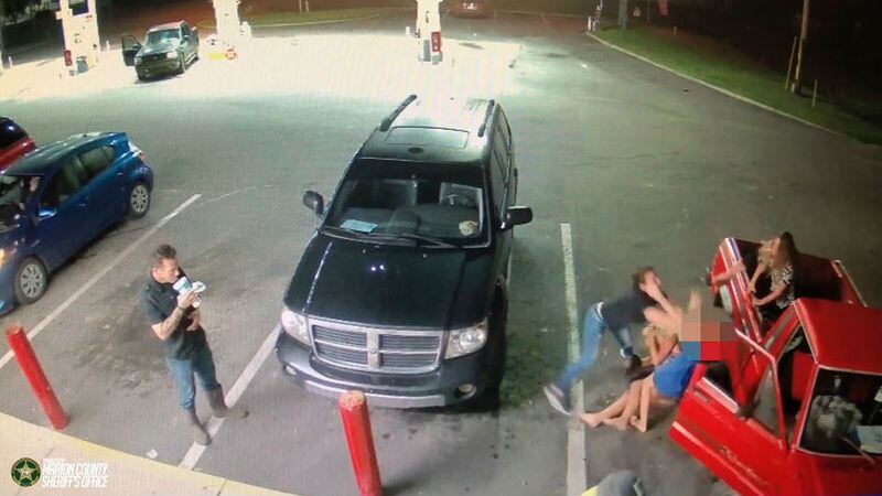 A still image from surveillance camera footage outside a Silver Springs, Florida, convenience store Sept. 22, 2018, shows a woman identified as Julia Marie Napiontek attacking a family of strangers -- including an 11-year-old girl -- in what Marion County Sheriff's Office officials said was an unprovoked attack. A bystander is seen watching the beating and sipping his fountain drink before getting back into his own car while the attack continued. Napiontek and Brandon Clanton, both 18, have been charged with battery in the case. Napiontek is also charged with aggravated child abuse and Clanton, with battery of a police officer.