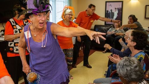 The Sing-Alongs member Mary Kay Kreisle (foreground) helps lead residents in songs at AG Rhodes at Wesley Woods in Decatur. For nearly nine years, the group calling itself the Sing-Alongs has been singing to patients in facilities in DeKalb and Fulton counties. Photo by Phil Skinner
