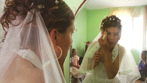 Gypsy bride Narcisa Tranca, 15, wipes her eye as she looks in a mirror during her wedding in 2003 on the outskirts of Bucharest, Romania, where such weddings are a rite of passage. Child marriages are pretty common here in the U.S. as well. AP PHOTO / MICHELLE KELSO