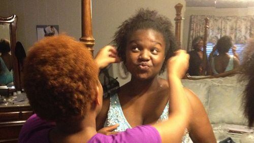 Quanesha Wallace, who was voted homecoming queen of Wilcox County High School this year but didn’t attend the homecoming dance, tries on a pair of earrings with her crystal blue prom dress at a friend’s Abbeville home Tuesday, April 23, 2013. (Contributed)