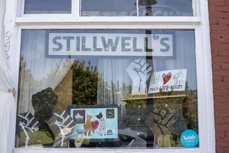 The storefront of Stillwell's Emporium displays racial justice solidarity signs in the downtown Stone Mountain. (ALYSSA POINTER / ALYSSA.POINTER@AJC.COM)