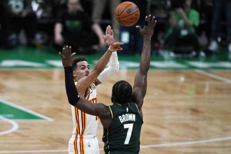 Atlanta Hawks guard Trae Young (11) takes the game-winning shot over Boston Celtics guard Jaylen Brown (7) during the final seconds of Game 5 in a first-round NBA basketball playoff series Tuesday, April 25, 2023, in Boston. (AP Photo/Charles Krupa)