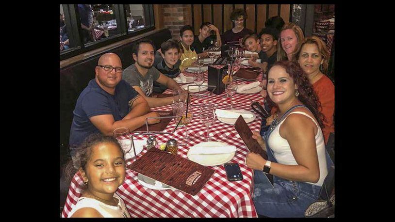 Jovanni Sierra (fourth from left in a yellow shirt) was enjoying his 13th birthday party Sunday night at Grimaldi’s Pizzeria at Downtown at The Gardens. He invited Corey Johnson (far end of the table, against the wall, with a maroon shirt and curly hair). The following day, Johnson stabbed Jovanni Sierra to death at a home in the BallenIsles Country Club in Palm Beach Gardens, police said. At the party was Jovanni Sierra’s mother Karen Abreu (right front), his father Oliver Abreu (left front, with glasses) and his sister Isabella (lower left).  (Photo courtesy Karen Abreu)