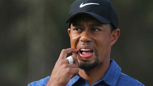 FILE - In this Feb. 2, 2017, file photo, Tiger Woods reacts on the 11th hole during the first round of the Dubai Desert Classic golf tournament in Dubai, United Arab Emirates. Woods pulled out of his next two tournaments because of ongoing back problems, a somber outlook for a 14-time major champion whose comeback barely lasted three tournaments before another setback. Woods said Friday, Feb. 10, 2017, on his website that he was still coping with back spasms that he attributed to his withdrawal from the Dubai Desert Classic last week. (AP Photo/Kamran Jebreili, File)