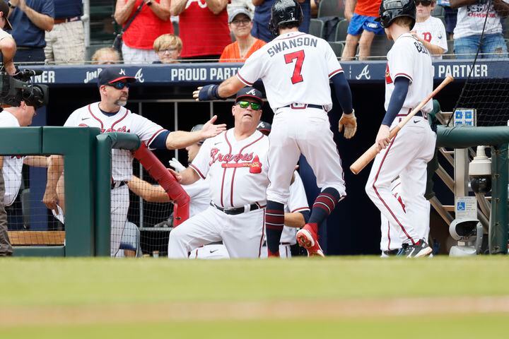Braves shortstop Dansby Swanson gets congratulated by manager Brian Snitker after he scored Sunday at Truist Park. (Miguel Martinez / miguel.martinezjimenez@ajc.com)