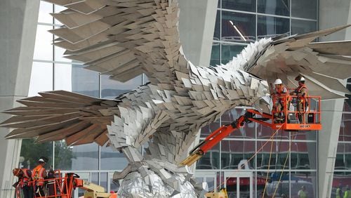 Workers install a 73,000-pound stainless steel sculpture of a falcon outside Mercedes-Benz stadium Thursday, April 27, 2017, in Atlanta.