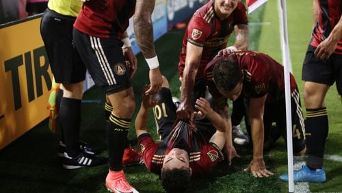 Atlanta United teammates pile on top of Miguel Almiron after he scored in the first half of Saturday’s game against Houston at Georgia Tech’s Bobby Dodd Stadium. (Miguel Martinez / Mundo Hispanico)