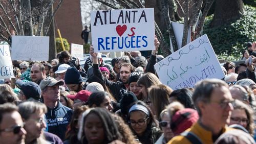 Richard Smiley, of Atlanta, holds a sign with a message to refugees as Redeemer Lutheran Church holds a rally to show support for Muslims and disdain for President Donald Trump's temporary travel ban and executive order calling for more stringent vetting of immigrants from some Muslim nations, Saturday, Feb. 4, 2017, in Atlanta. (John Amis)