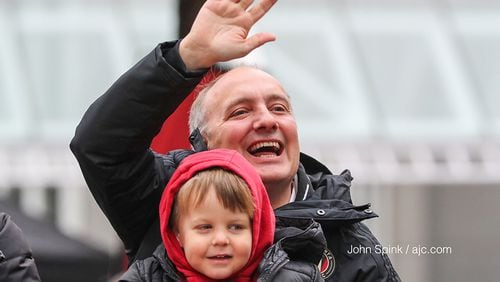 Atlanta United President Darren Eales waves to the crowds of cheering fans along the championship parade route on Dec. 10, 2018, in downtown Atlanta.