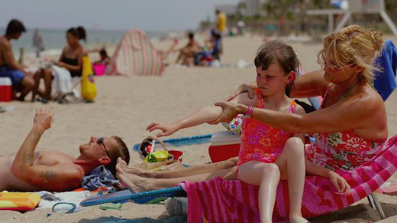 Sharon Doyle puts sunscreen on the arm of 9-year-old Savannah Stidham as they visit the beach June 20, 2006 in Fort Lauderdale, Florida. Photo: Joe Raedle/Getty Images