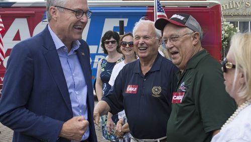 Lt. Gov. Casey Cagle, left, greets J.T. Williams, Warren Holder and Vikki Consiglio, left to right, Thursday in McDonough Square during one of Cagle’s bus tour stops for his campaign for Georgia governor. Jenna Eason / Jenna.Eason@coxinc.com