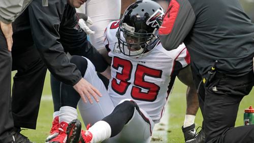 Team members assist Atlanta Falcons' Antone Smith (35) after Smith was injured in the second half of an NFL football game against the Carolina Panthers in Charlotte, N.C., Sunday, Nov. 16, 2014. (AP Photo/Bob Leverone)