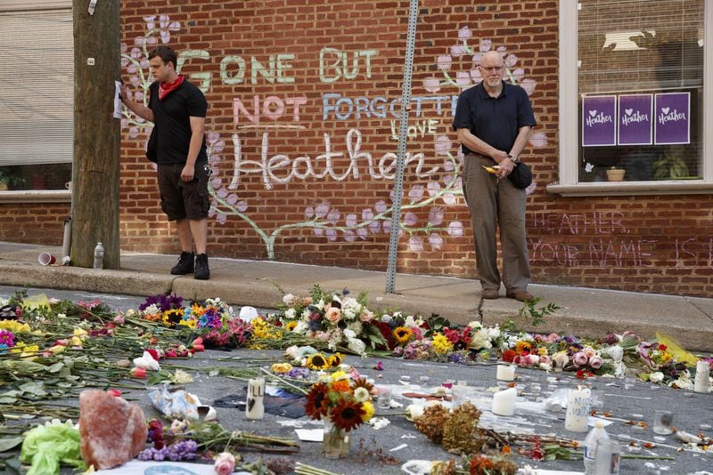 Jason Charter (left) of Washington stands at a memorial Wednesday in Charlottesville, Va., at the site where Heather Heyer was killed during a white nationalist rally. Charter was at the scene when a car rammed into a crowd of people protesting the rally. AP PHOTO / EVAN VUCCI