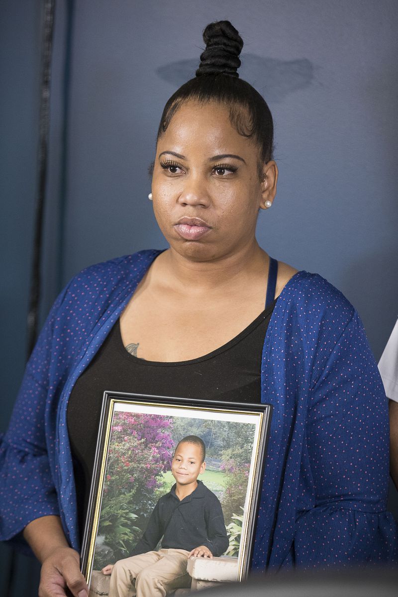 Allison Woods holds a photo of her son Isaiah Payton. The 12-year-old was shot after a football game in August and remains hospitalized. AJC photo: Alyssa Pointer