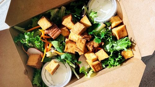 The tropical salad with smoked tofu from El Super Pan is made with local greens and topped with avocado, cherry tomatoes, palm hearts, green olives and pepitas. Henri Hollis for The Atlanta Journal-Constitution