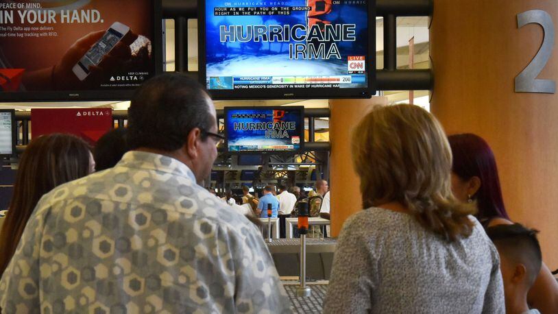 Airport customers watch CNN Airport News in the baggage claim area at Hartsfield-Jackson Atlanta International Airport on Friday, September 8, 2017. HYOSUB SHIN / HSHIN@AJC.COM