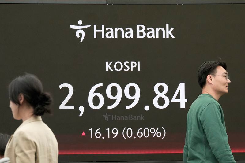 Currency traders pass by the screen showing the Korea Composite Stock Price Index (KOSPI) at the foreign exchange dealing room of the KEB Hana Bank headquarters in Seoul, South Korea, Friday, May 3, 2024. Asian shares were mostly higher Friday ahead of a report on the U.S. jobs market, with several major markets including Tokyo and Shanghai closed for holidays. (AP Photo/Ahn Young-joon)