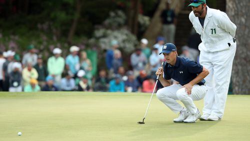 Jordan Spieth and his caddie Michael Greller prepare to putt on the 15th green during the first round of the 82nd Masters on Thursday, April 5, 2018, at Augusta National Golf Club. PHOTO / JASON GETZ