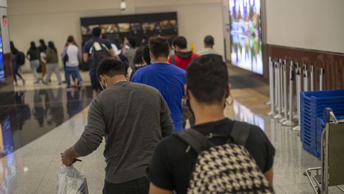 A group of immigrants and asylum seekers follow members of Casa Alterna as they are guided through the domestic terminal at Atlanta's Hartsfield-Jackson International Airport, Thursday, Aug. 19, 2021. (Alyssa Pointer/Atlanta Journal Constitution)