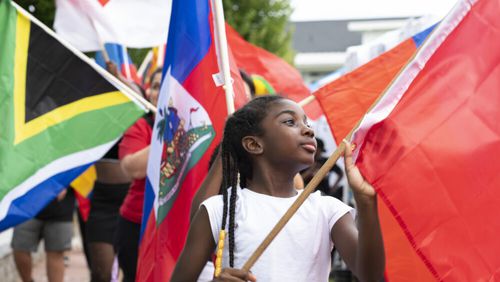 A young festivalgoer holds up the Moroccan flag during the flag parade at the "Around the World in the DTL" in Lawrenceville, Ga. September 9, 2022. (Kendra A. Ransum/Fresh Take Georgia)