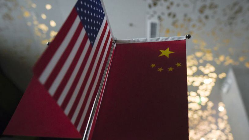 Chinese flags and American flags are displayed in a company in Beijing on Aug. 16, 2017. (Photo by WANG ZHAO/AFP via Getty Images/TNS)