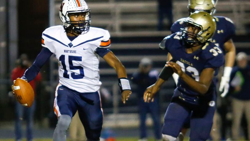 Northside Warner Robins quarterback Jadin Daniels (15) looks for a receiver under pressure from Dacula defenders during Friday's Class AAAAAA semifinal in Dacula. (Casey Sykes/Special)