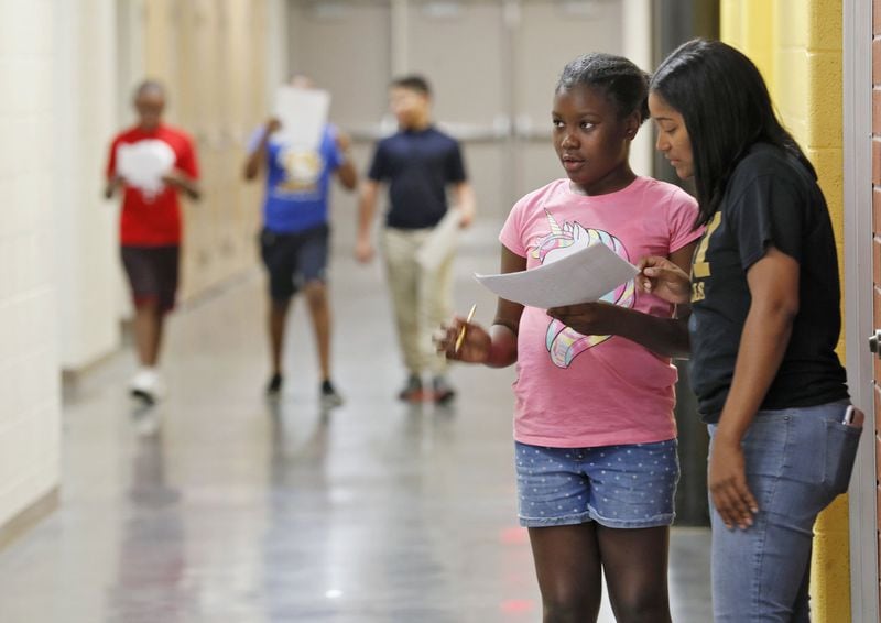 Gabrielle Burch, 11, gets some help from Sakeenah McDonald, the sixth-grade counselor, as she looks for the music room on a scavenger hunt. The purpose is to help them learn the layout of the school. Incoming sixth-graders at Sylvan Hills Middle School take part in the summer bridge program designed to help students leaving elementary school adjust to their new life as middle schoolers. BOB ANDRES / ROBERT.ANDRES@AJC.COM